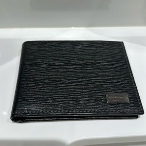 Black Ferragamo bifold wallet with metal plate. New with tags and box.